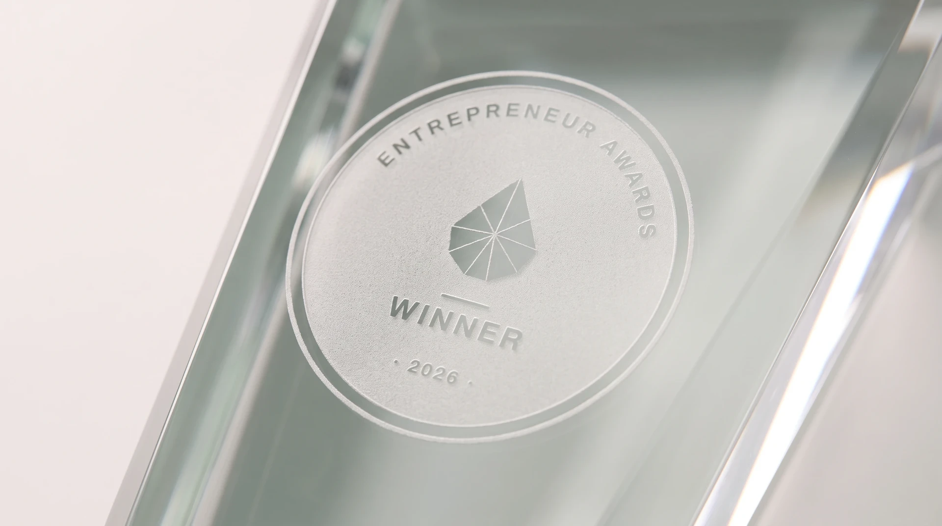 Close detail of the 2026 Entrepreneur Award, showing the winner seal etched into the crystal.